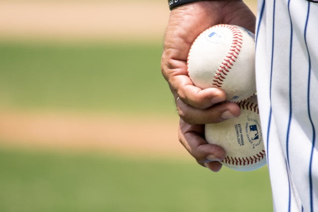 Person holding two baseballs in their hand 